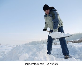 Man Clearing Path From Snow With Snow Shovel After Heavy Blizzard