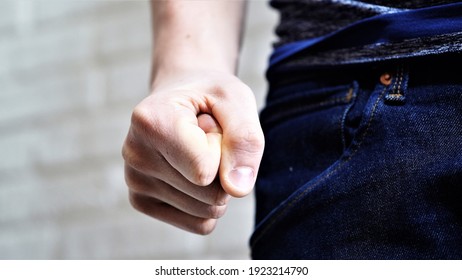 A man with a clenched fist is abusing the family. Home violence. The husband oppresses his loved ones. Physical violence - Shutterstock ID 1923214790