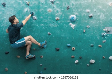 A man climbing in boulder gym in the wall. - Powered by Shutterstock