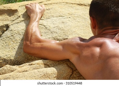 Man Climbing On Mountain Rocks. Close Up On Muscular Back And Hands. Extreme Sports Outdoors. Active Summer Vacation