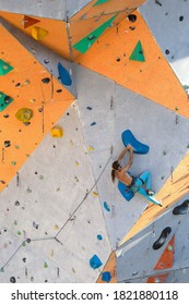 A man climbs a climbing wall, a climber is training on artificial terrain, rock climbing in the city, a strong man, sports in the city, safety in extreme sports. - Shutterstock ID 1821880118