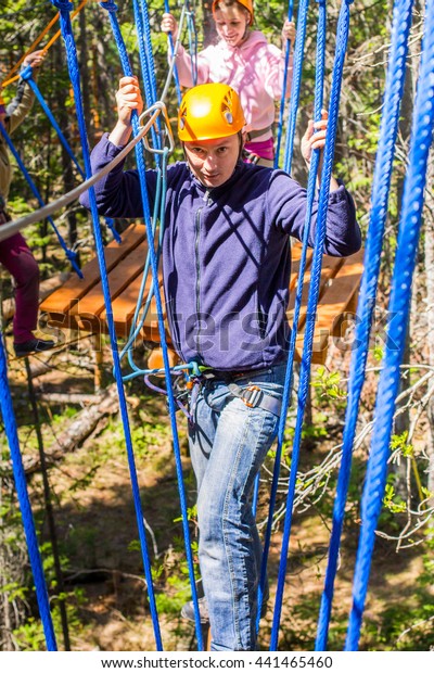 The man climbs into ropes\
course