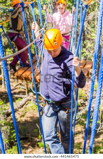 The man climbs into ropes\
course