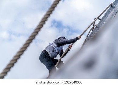 A man climbs an obstacle at a sporting event. Self development - Powered by Shutterstock