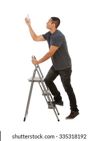 Man Climbs Stepladder To Replace Light Bulb