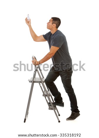 Man Climbs Stepladder To Replace Light Bulb