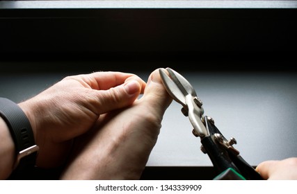 Man Clipping Toenails With Sheet Metal Shears