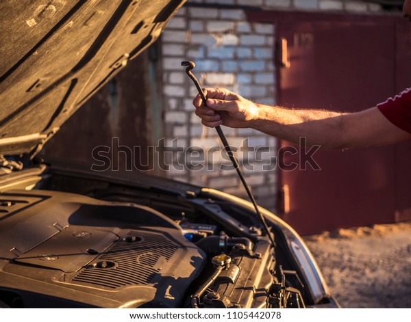 man close the car\
hood after repairing it 