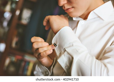 The Man Closes Cuff Links. White Shirt.