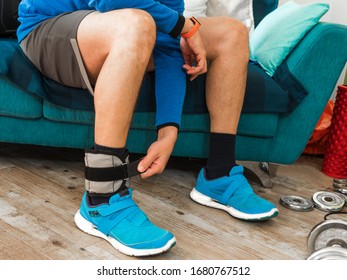 Man Closing Velcro Strap Of An Ankle Weight During A Home Workout