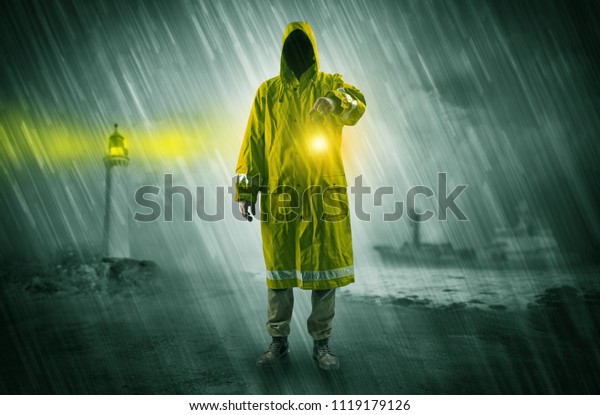 Man at the coast coming in raincoat with glowing\
lantern concept