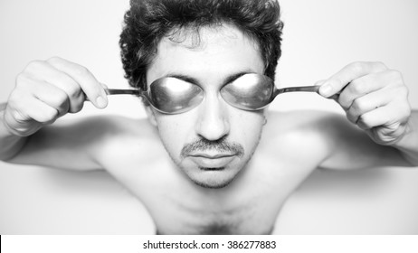 Man With Coffee Spoons On His Eyes As If They Were Goggles