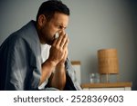 Man with cold and flu virus blowing nose at home. Copy space. 