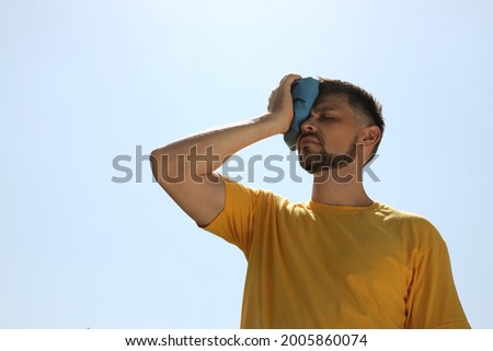 Man with cold pack suffering from heat stroke outdoors