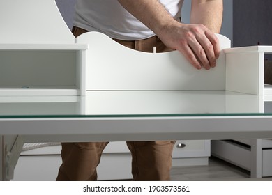 Man Collects White Dressing Table At Home. Furniture Assembly Concept