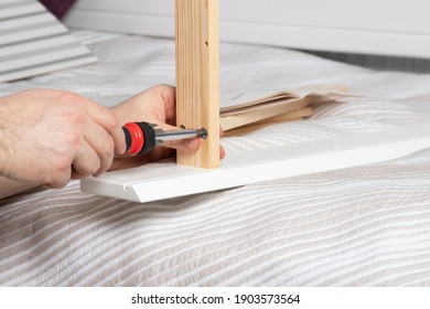 Man Collects White Dressing Table At Home. Furniture Assembly Concept