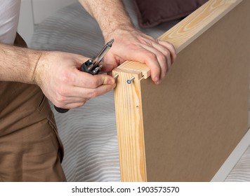 Man Collects White Dressing Table At Home. Furniture Assembly Concept