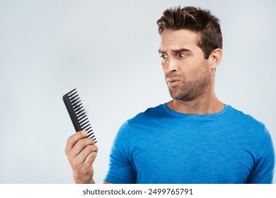 Man, comb and worry for hair loss in studio with crisis, genetic disease and thyroid problem. Male person, stress and alopecia risk with beauty tool, testosterone issue and aging by white background