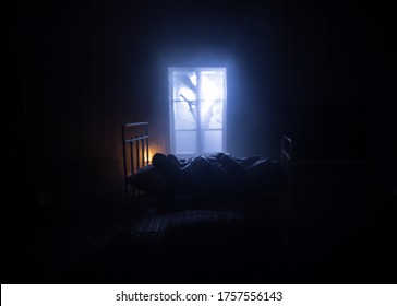 Man comfortably sleeping in his bed at night. A realistic dollhouse bedroom with furniture and window at night. Selective focus