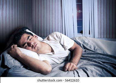 Man Comfortably Sleeping In His Bed At Night