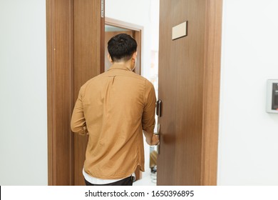 Man Coming Home From Work And Opening Door Of Apartment