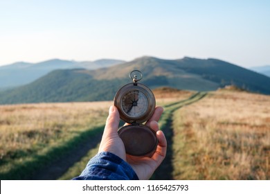 Man With Compass In Hand On Mountains Road. Travel Concept. Landscape Photography