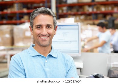 Man At Computer Terminal In Distribution Warehouse