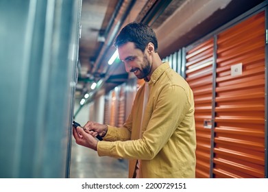 Man Concentrated On Padlocking The Storage Unit Door