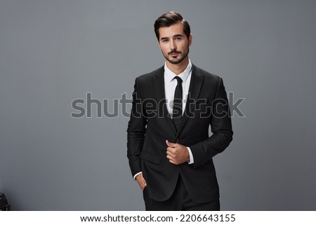 Man confident businessman in a stylish suit with jacket tie and white shirt on a gray background portrait. The concept of young businesses and startups