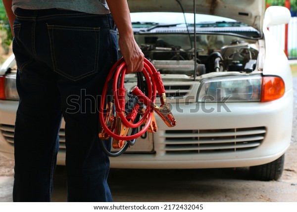 \
Man Connecting Battery Cable Copper Wire For\
Repairing Jumpers And Electrical Maintenance Of Engines Car\
problems that won\'t\
start.