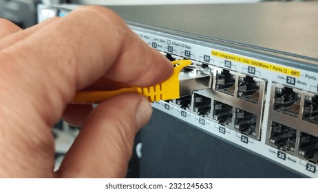 Man connecting network cable to switch