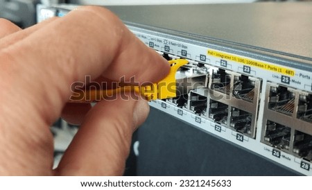 Man connecting network cable to switch