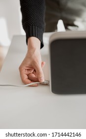 Man connects network lan cable to laptop with his hand. Close up shot, white background - Shutterstock ID 1714442146