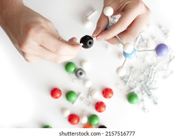 Man Constructing A 3d Chemistry Molecule Model From Colourful Balls And Sticks During A Demonstration In Class In A Close Up On His Hands