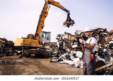 Man controlling process of industrial scrap metal lifting at junk yard. - Powered by Shutterstock