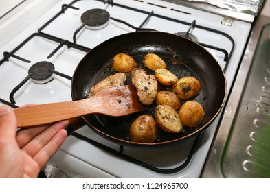 Man Cooking Chicken Wings With Potatoes Lying On The Frying Pan On The Oven. Homemade Lunch. Unhealthy Food Photo With Fat.