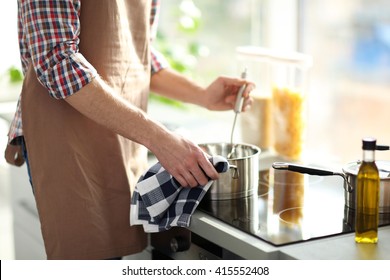 Man Cooking Dinner In Bright Kitchen