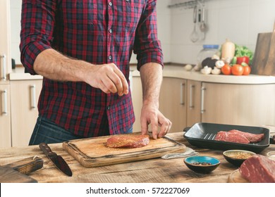 Man Cooking Grilled Steak On The Home Kitchen.