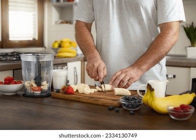 Man cooking healthy banana strawberry cocktail standing in the home kitchen. Healthy lifestyle concept - Powered by Shutterstock