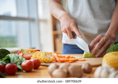 Man Cooking Healthy Meal At His Kitchen