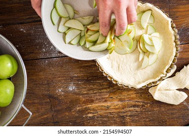 Man cooking homemade french apple pie on wooden table top view. Raw ingredients for making apple tart