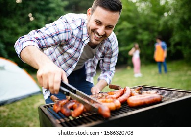 Man cooking meat on barbecue grill at outdoor summer party - Powered by Shutterstock