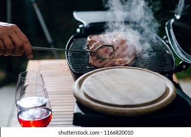 Man Cooking Medium Rare Steaks For Dinner On The Grill. Outdoors On The Backyard. Date Night. BBQ.