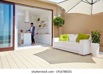 man cooking on cozy open space kitchen with rooftop patio and sliding doors