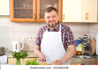 A Man Is Cooking A Vegetarian Burger. An Adult 40 Year Old Man Leads A Healthy Diet.