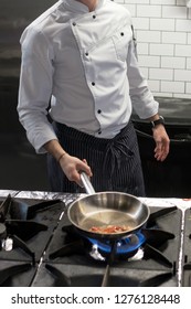 A Man Cooks Cooking Deep Fryers In A Kitchen Fire.