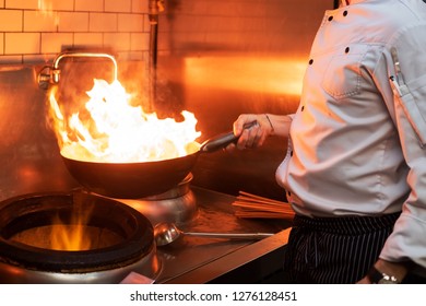 A Man Cooks Cooking Deep Fryers In A Kitchen Fire.