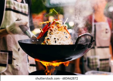 Man cooks noodles on the fire