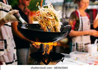 Man cooks noodles on the fire
