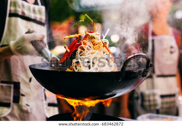 Man cooks noodles on the\
fire